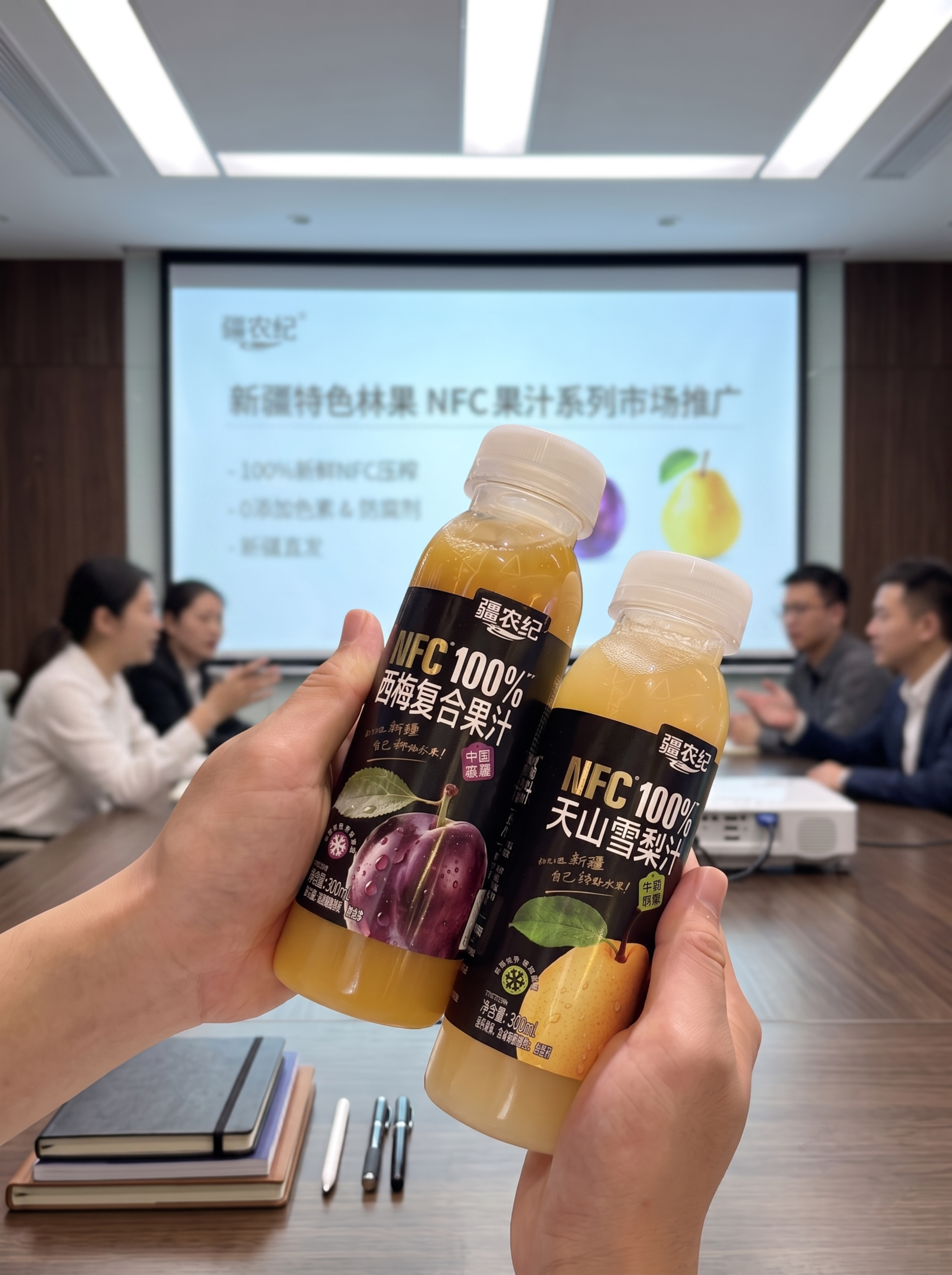 保留双手拿两瓶果汁，放在会议室会议桌，投影背景模糊，同事们正在… - 图片创意预览