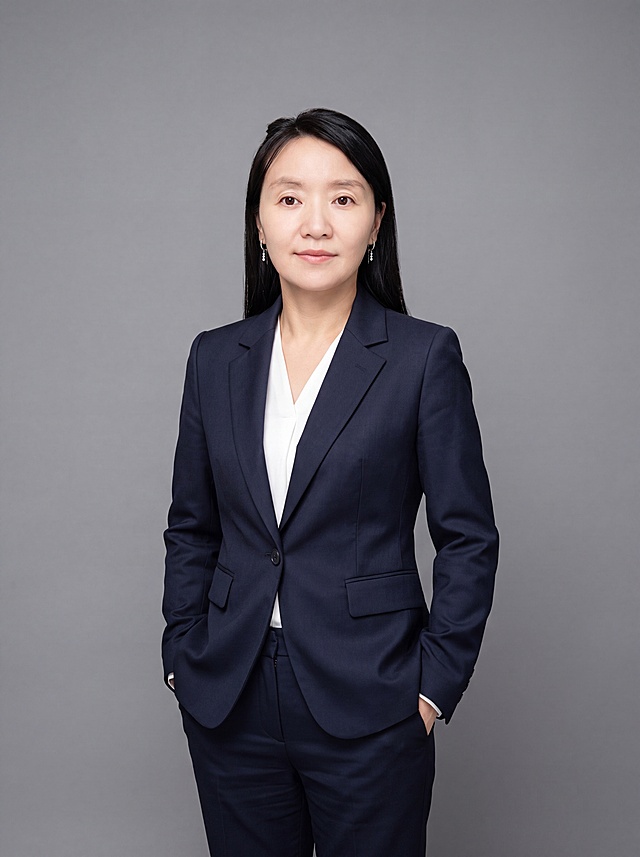 参考图中保留人物脸型、发型、年龄等特征生成职场形象照，全身照，展现人物完整身形。标准焦段50mm，f/4光圈，平视视角，镜头与人物视线齐平；人物占画面合理空间，人物居中，居中构图，位于画面中心，为视觉聚焦点，全身照；头部与画面顶部保留合适空间，头部发型完整，头身比例协调，人物结构准确。身穿藏青色精纺羊毛混纺西装外套，平驳领设计，面料呈细腻微微哑光质感；内搭白色高支精梳棉衬衫；下装藏青色精纺羊毛混纺西装裤；着装正式干练，专业稳重；身形匀称，姿态端正，身体挺拔。呈自然站姿，双手插兜，肢体放松且自信。发质微微柔顺，微微蓬松。佩戴精致耳环配饰。简约中性灰色纯色背景，呈现均匀柔和质感，背景光线均匀柔和，强化色彩对比的高级感，极简干净。画质超高分辨率、细节清晰，现代精致感风格；肤质精细化处理；眼神直视镜头，目光坚定且澄澈，表情自然。嘴角上扬。清透自然裸妆，轻薄底妆+淡唇妆，妆感轻薄轻透裸肌感，通透感肤质，肤质自然细腻，肤色健康均匀，雾面柔光裸肌感，保留真实皮肤细节。正面柔光补光，4800K中性光，面部光比1:1.5，色调明亮。中近景写实摄影，对焦清晰，高清保留皮肤细节。分辨率4K，去除人物之外的所有多余元素，严格按照图片内容生成。画面比例3:4