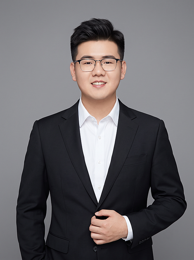 参考图中保留人物脸型、发型、年龄等特征生成职场形象照，标准焦段50mm，f/4光圈，平视视角；人物占画面70%，人物居中，位于画面中心，为视觉聚焦点，半身像；左右留少量背景空间；头部与画面顶部保留5%空间；头部发型完整，头肩比例协调，人物结构准确；发质微微柔顺，微微蓬松；身穿深黑色精纺羊毛混纺西装外套，平驳领设计，面料呈细腻微微哑光质感；内搭白色高支精梳棉衬衫；下装深黑色精纺羊毛混纺西裤；着装正式干练；专业稳重，身形匀称，姿态端正，身体挺拔。呈右手轻握西装前襟的自然站姿，肢体放松且自信；佩戴眼镜，保留配饰；简约微微中度灰色纯色背景，呈现均匀柔和质感，背景光线均匀柔和，强化色彩对比的高级感，极简干净；画质超高分辨率、细节清晰，现代精致感风格；肤质精细化处理；眼神直视镜头，目光坚定且澄澈，表情自然，嘴角上扬；肤质自然细腻，肤色健康均匀，皮肤状态清爽干净，保留真实皮肤细节。正面柔光补光，4800K中性光，面部光比1:1.5，中近景写实摄影，对焦清晰，面部雾面柔光，轻透裸肌感，高清保留皮肤细节；分辨率4K，去除人物之外的所有元素，严格按照图片内容生成；画面比例3:4
