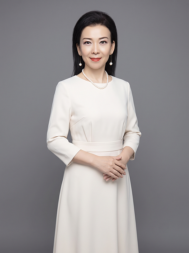 参考图生成，保留原人物长相五官特征不变，半身形象照，摄影棚级，背景换成干净的中性灰色纯色背景，穿搭为米白色纯色收腰连衣裙，自然站姿双手交叠身前，保持自然真实感，不改变长相，专业打光，画质高清，半身形象照，分辨率4K