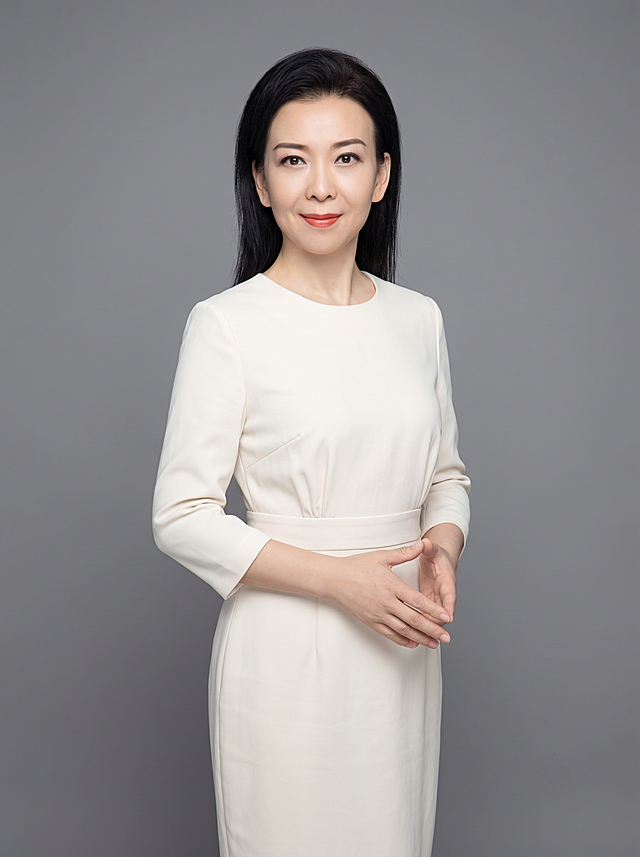 参考图重新生成，保留原人物长相五官不变，半身形象照，摄影棚拍摄，纯色中性灰色背景，穿米白纯色收腰连衣裙，去掉所有首饰，双手交叠站姿，真实自然，高清，专业打光，半身照，4K