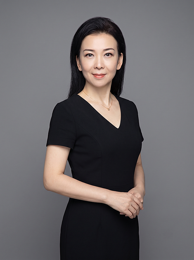 参考图重新生成，保留原人物长相五官不变，半身形象照，摄影棚拍摄，纯色中性灰色背景，穿黑色V领连衣裙，只留细项链，去掉其他首饰，身体微侧，真实自然，高清，专业打光，半身照，4K