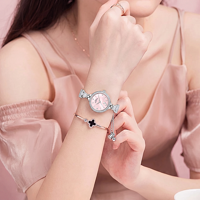 请将参考图 1 的【女士手表】1:1 还原其形态、品牌标识、细节纹理、五金件等所有细节，佩戴到参考图 2 模特的手腕上；保持参考图 2 模特的身姿、面部、发型、气质、动作不变，模特身上未覆盖部位严格保持参考图 2 原样；画面背景、光影、构图、景别严格保持参考图 2 原样，参考图 2 整体风格相似度保持 50%；手表穿戴位置合理，与手腕自然接触，人体结构正确。生成图片比例 1:1，分辨率为4K。