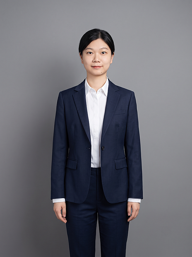 参考图中保留人物脸型、发型、年龄等特征生成职场正装全身形象照，标准焦段50mm，f/4光圈，平视视角，镜头与人物视线齐平；全身照，展现人物完整身形，人物占画面中心，为视觉聚焦点，全身完整，头脚空间比例协调；头部发型完整，头身比例协调，人物结构准确；身穿藏蓝色精纺羊毛混纺西装外套，平驳领设计，面料呈细腻微微哑光质感；内搭白色高支精梳棉衬衫；下装藏蓝色精纺羊毛混纺西裤；着装正式干练，专业稳重；身形匀称，姿态端正，身体挺拔。呈站姿双手自然下垂，肢体放松且自信；发质微微柔顺，微微蓬松，发梢微微修整，干练大气，主体锐利；简约微微中度中性灰色纯色背景，呈现均匀柔和质感，背景光线均匀柔和，强化色彩对比的高级感，极简干净；画质超高分辨率、细节清晰，现代精致感风格；肤质精细化处理；眼神直视镜头，目光坚定且澄澈，表情自然，嘴角上扬；清透自然裸妆，轻薄底妆+淡唇妆，妆感轻薄轻透裸肌感，通透感肤质，肤质自然细腻，肤色健康均匀，雾面柔光裸肌感，保留真实皮肤细节，正面柔光补光，4800K中性光，面部光比1:1.5，色调明亮，写实摄影，对焦清晰，高清保留皮肤细节；保留配饰；分辨率4K，去除人物之外的所有元素。严格按照图片内容生成，画面比例3:4