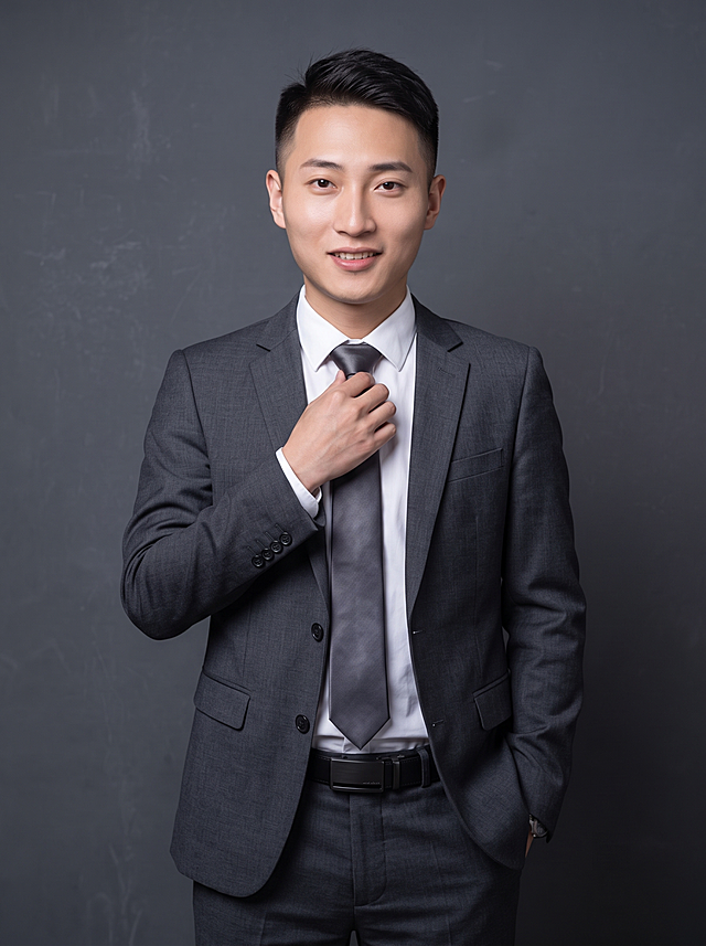 参考图中保留人物脸型、发型、年龄等特征生成职场商务形象照,标准焦段50mm,f/4光圈(f/2.8-f/4区间),平视视角(镜头与人物视线齐平);人物占画面70%,人物居中(居中构图),位于画面中心,为视觉聚焦点,入境范围头部及以下至臀部下方10cm(半身像);左右留少量背景空间;头部与画面顶部保留5%空间;头部发型完整,头肩比例协调,人物结构准确;身穿修身精纺羊毛混纺面料的深灰色西装外套,平驳领设计,商务感正式感,面料呈细腻微微哑光质感;内搭白色翻领衬衣;搭配高级深灰色领带,含5%桑蚕丝提升柔光质感;下装精纺羊毛混纺面料的高级深灰色西裤,面料同西装;搭配暗色哑光皮带,宽1.5cm,带扣为长方形拉丝黑色金属,尺寸1.8cm×2.5cm;着装正式干练;专业稳重;身形匀称,姿态端正,身体挺拔。呈站立姿势,一手轻调整领带,另一手插于裤兜,肢体放松且自信;发梢微微修整,干练大气,主体锐利,背景光线均匀柔和,强化色彩对比的高级感。简约冷调深灰色纯色背景,呈现均匀柔和质感,极简干净;画质超高分辨率、细节清晰,现代精致感风格;肤质精细化处理;眼神直视镜头,目光坚定且澄澈,表情自然。嘴角上扬;肤质自然细腻,肤色健康均匀,哑光肤质清爽干净,保留真实皮肤细节;杰作,最佳画质,超高细节,写实摄影,中近景人像,皮肤质感自然清晰,柔光,正面补光,画面干净清新,高清皮肤细节;面部光比1:1.5,4800K中性光,微微修饰脸型,肤质哑光细腻,面部雾面柔光,轻透裸肌感,真实毛孔纹理;分辨率4K,严格按照图片内容生成,画面比例3:4