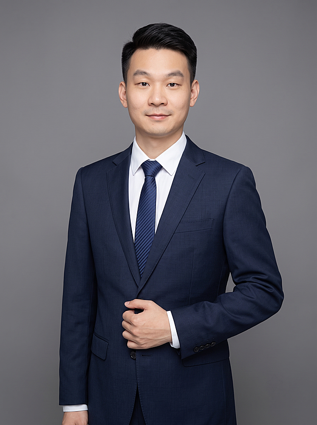 参考图中保留人物脸型、发型、年龄等特征生成职场形象照,标准焦段50mm,f/4光圈(f/2.8-f/4区间),平视视角(镜头与人物视线齐平);人物占画面70%,人物居中(居中构图),位于画面中心,为视觉聚焦点,全身照,展现人物完整身形;左右留少量背景空间;头部与画面顶部保留5%空间;头部发型完整,头肩比例协调,人物结构准确;身穿深藏青色精纺羊毛混纺西装外套,(平驳领设计,面料呈细腻微微哑光质感);内搭白色高支精梳棉衬衫,搭配深蓝色条纹领带;下装深藏青色精纺羊毛混纺西裤;着装正式干练;专业稳重、从容自信;身形匀称,姿态端正,身体挺拔。呈自然站姿，右手轻握西装前襟，肢体放松且自信;发梢微微修整,干练大气,主体锐利。简约微微中度灰色纯色背景(呈现均匀柔和质感),背景光线均匀柔和,强化色彩对比的高级感。极简干净;画质超高分辨率、细节清晰,现代精致感风格;肤质精细化处理;眼神直视镜头,目光坚定且澄澈,表情自然。嘴角微微上扬;肤质自然细腻,肤色健康均匀,皮肤状态清爽干净,保留真实皮肤细节。正面柔光补光,4800K中性光,面部光比1:1.5。中近景写实摄影,对焦清晰,面部雾面柔光,轻透裸肌感,高清保留皮肤细节。分辨率4K,去除人物之外的所有元素。严格按照图片内容生成。画面比例3:4