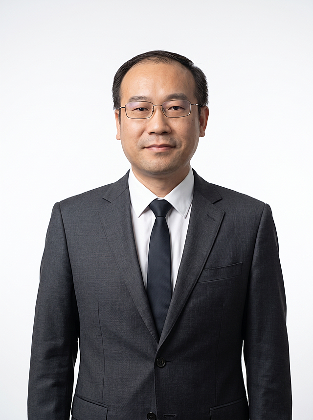 参考图中人物的面部特征、发型、年龄和眼镜，生成职业经理形象照。标准焦段50mm，f/4光圈，平视视角，镜头与人物视线齐平。人物占画面70%，人物居中构图，位于画面中心为视觉聚焦点，上半身半身照，左右留少量背景空间，头部与画面顶部保留5%空间，头肩比例协调，人物结构准确。身穿深灰色精纺羊毛混纺西装外套，平驳领设计，面料呈细腻微微哑光质感；内搭白色高支精梳棉衬衫；系深色领带；着装正式干练，专业稳重，身形匀称，姿态端正，身体挺拔。呈自然站姿，双手自然垂于身体两侧，肢体放松且自信。佩戴眼镜，保留眼镜特征，去除工牌和挂绳，去除项链、耳环、包包、帽子等配饰。发梢微微修整，干练大气，主体锐利。纯白色背景，呈现均匀柔和质感，极简干净，背景光线均匀柔和，强化色彩对比的高级感。画质超高分辨率、细节清晰，现代精致感风格。肤质精细化处理，眼神直视镜头，目光坚定且澄澈，表情自然，嘴角微微上扬。肤质自然细腻，肤色健康均匀，哑光肤质清爽干净，保留真实皮肤细节。杰作，最佳画质，超高细节，写实摄影，中近景人像，皮肤质感自然清晰，柔光，正面补光，画面干净清新，高清皮肤细节。面部光比1:1.5，4800K中性光，微微修饰脸型，肤质哑光细腻，面部雾面柔光，轻透裸肌感，真实毛孔纹理。画面比例3:4