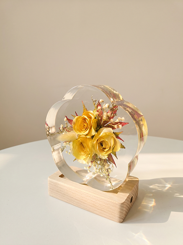 产品为梅花形树脂干花摆件，包含梅花形透明树脂块和原木底座，干花为三朵黄色玫瑰搭配狗尾草、红叶和浅色配草。保持产品主体物理结构绝对不变，不改变产品结构，产品中每张图只出现一次。树脂部分必须清亮透明犹如玻璃，画面干净无浮尘物。放置在浅白色哑光台面上，侧光拍摄，阳光从侧面照射，增强透光感，阳光透过透明树脂形成美丽的光斑。背景是浅米色墙面，干净简洁。侧视角度构图，展示产品侧面透光质感。柔和暖调阳光，低对比度。商业级4K摄影，画面通透干净，符合国内电商种草风格。保持3:4画面比例。负向词：西方面孔,金发,深眼窝,雀斑,杂乱房间,死黑阴影,硬光,乡村风,高对比度,欧美妆容,变形,扭曲,穿模,重叠,比例失调,浮尘,脏污,树脂浑浊,多个产品
