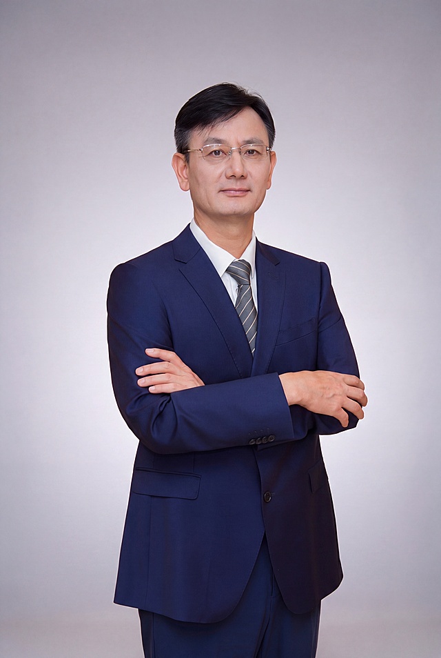 参考图3的浅灰色渐变精英商务背景，将图2人物的背景替换为该背景色，人物的五官、发型、眼镜、深蓝色西装、白衬衫、灰条纹领带、双臂交叉的站姿全部保持不变，生成精英商务形象照，画质精致专业