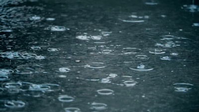  慢动作建立雨滴落在人行道上的镜头。