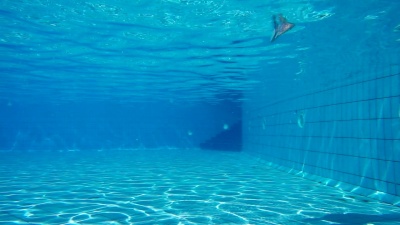 女孩跳进游泳池在水下游泳