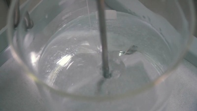 将玻璃杯中的粘性液体与药用搅拌器混合的过程