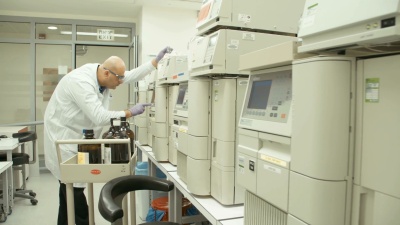 在制药实验室中使用质谱仪进行实验的科学家