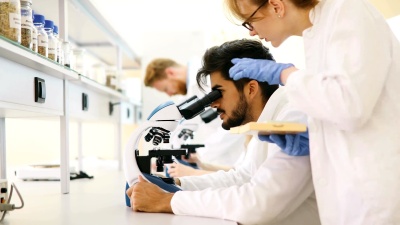 年轻科学家在实验室通过显微镜看