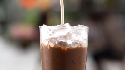 将牛奶倒入一杯冰咖啡