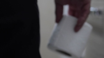 一名男子在浴室拿着卫生纸卷