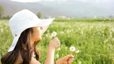 慢动作女孩用蒲公英种子旋转