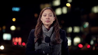 亚洲女记者夜间从市中心现场报道