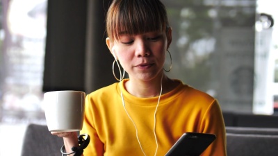 现代咖啡馆里听音乐的女人