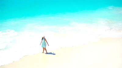 海滩上可爱的女孩在浅水中玩得很开心