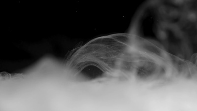 在黑色背景上拍摄的水中的白色油墨效果
