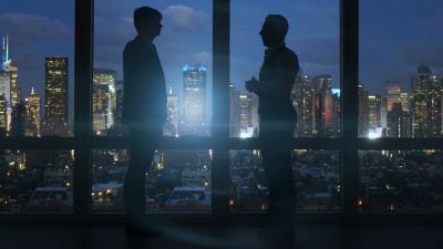 穿着工作服的白种人员工用电脑工作。以城市景观为背景。