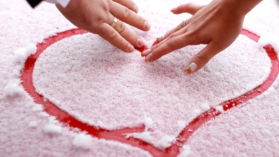 一对相爱的夫妇在雪中画了一颗心