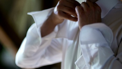 男人扣子衬衫特写。穿好衣服的男人。穿上男士的衣服。男士的手。