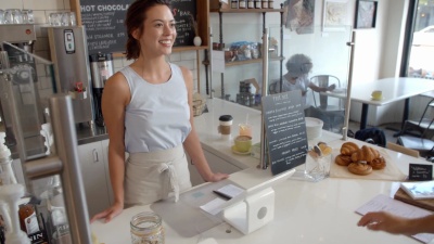 咖啡店的顾客用卡片付给微笑的女服务员