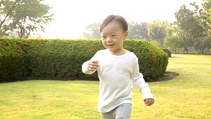 小男孩在花园里跑步慢动作
