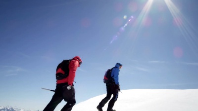 登山者在白雪覆盖的山上行走