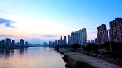 黄昏时河边城市风光的流逝。