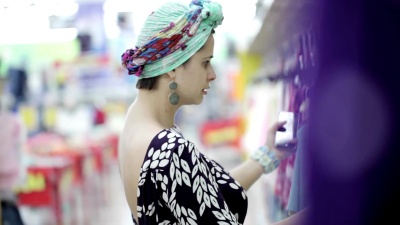 美女在超市挑选婴儿服装。