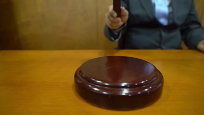 面目全非的法官敲击小木槌以求安静