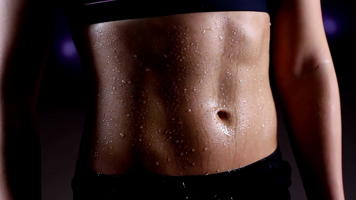 健身房运动女子训练理想平坦的腹部水滴倾泻而下