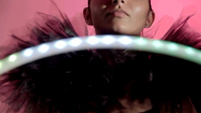 为广告拍摄时尚肖像。带LED呼拉圈的拉丁女孩