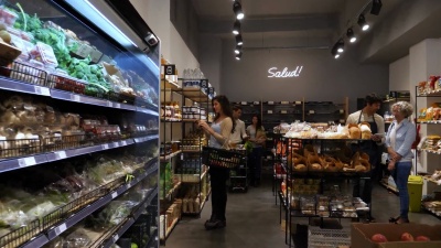 有机食品店的顾客看着货架，挑选着产品，看起来都很开心，微笑着