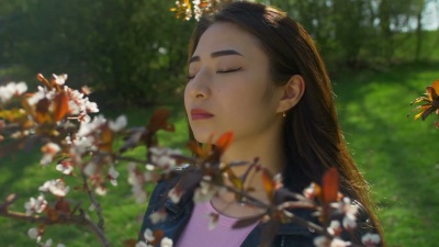 盛开的樱花花园里的年轻亚洲女人