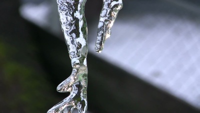 水从融化的冰柱上滴下来