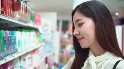 一名妇女在商店的货架上挑选产品