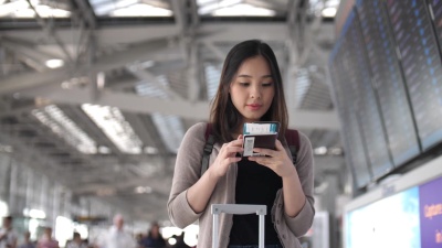 游客在机场使用电话在线办理登机手续