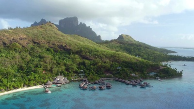 空中飞行 在阳光明媚的夏天，飞往波拉岛的豪华酒店度假胜地，在壮丽的博拉岛上拥有豪华的水上别墅。