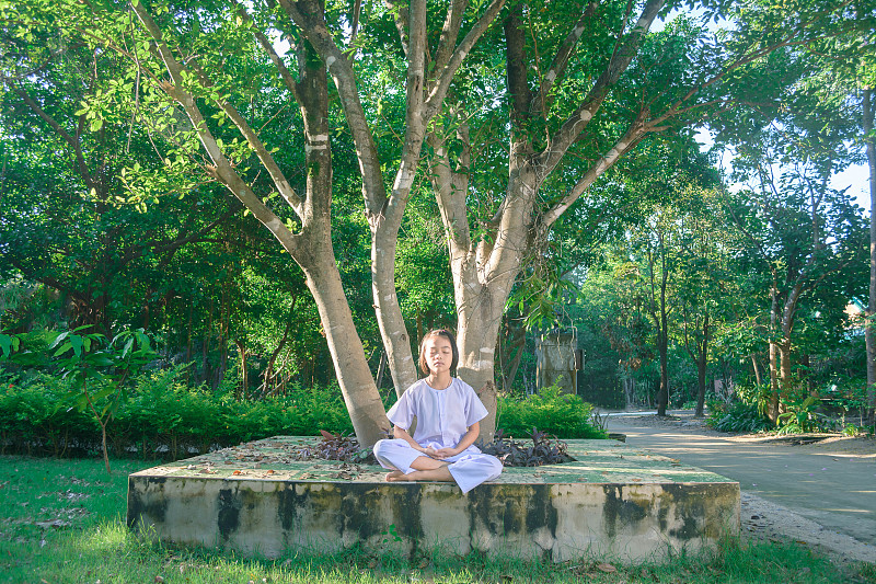 穿着白色衣服的孩子，在大树下练习静坐，内心平静