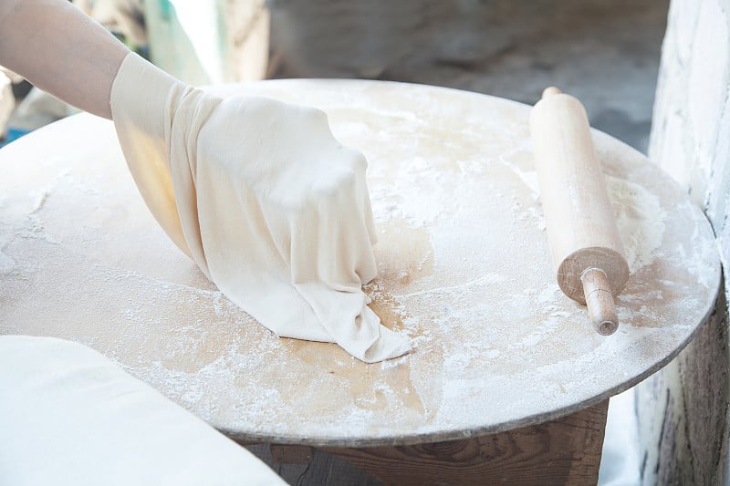 Woman preparing armenian bread lavash.