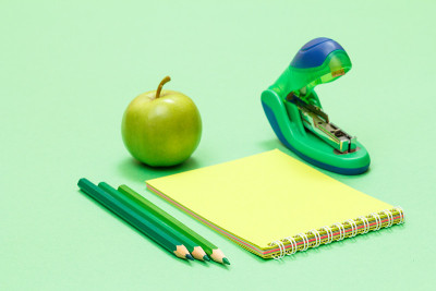 学习用品。彩色铅笔，笔记本，苹果和订书机。