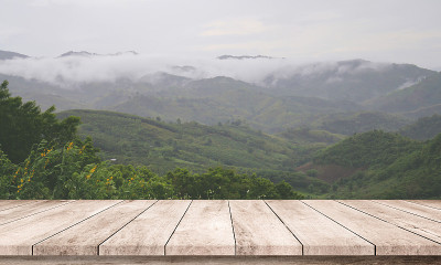 以雨云和山岳自然为背景的木桌或木地板