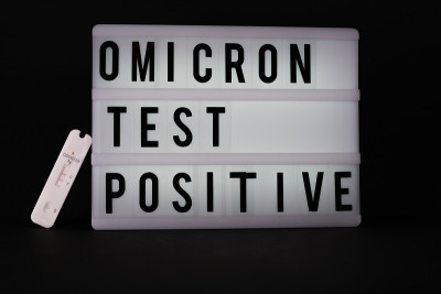 在一块刻有“Omikron检测阳性”字样的光板旁边，放置着一份新冠抗原快速检测阳性的纸条