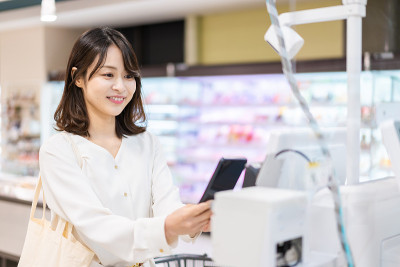 年轻女子使用自助结账和电子货币支付