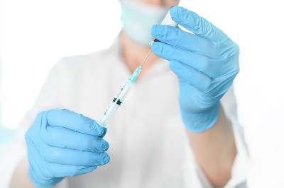 医生、护士、科学家、研究员手戴蓝色手套，手持流感、麻疹、冠状病毒、covid-19疫苗疾病，准备进行