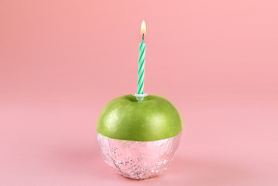 Green apple in aluminium foil with a lighted candl